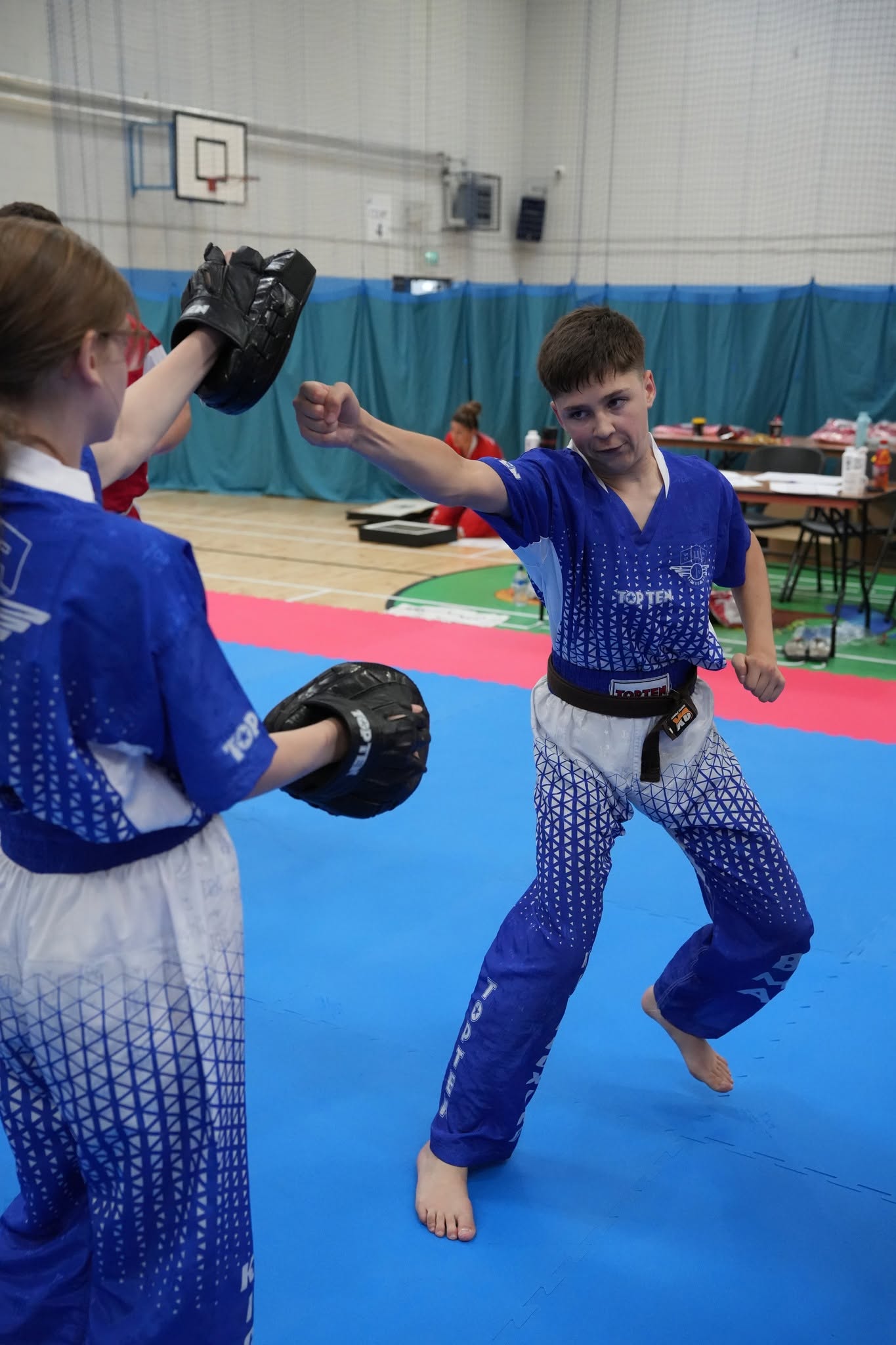 Bushido student practising a controlled kick during pad training